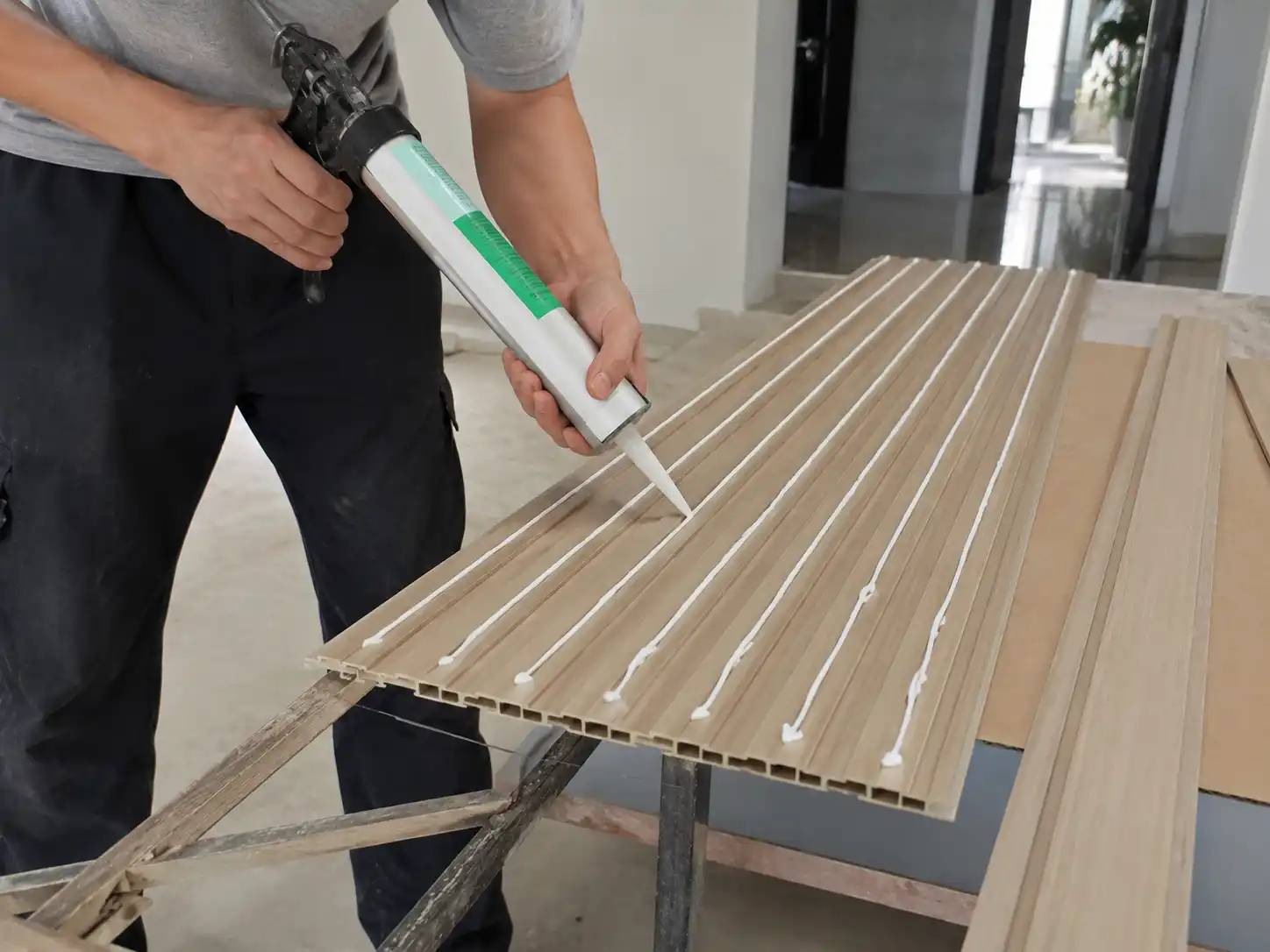 Adhesive application on the back of fluted wall panel before installation