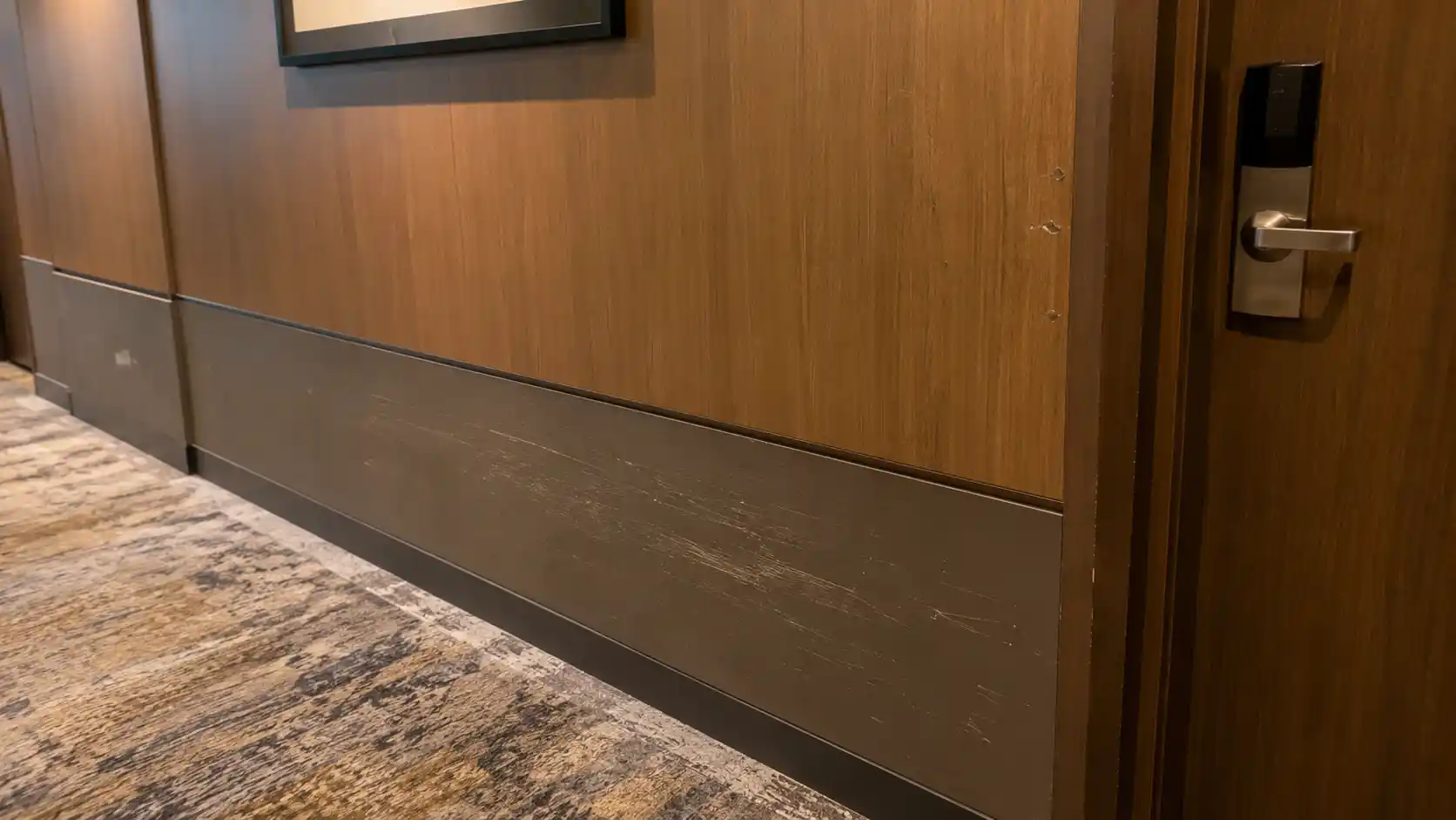Hotel corridor wall damage from luggage scuffs carts and daily guest traffic